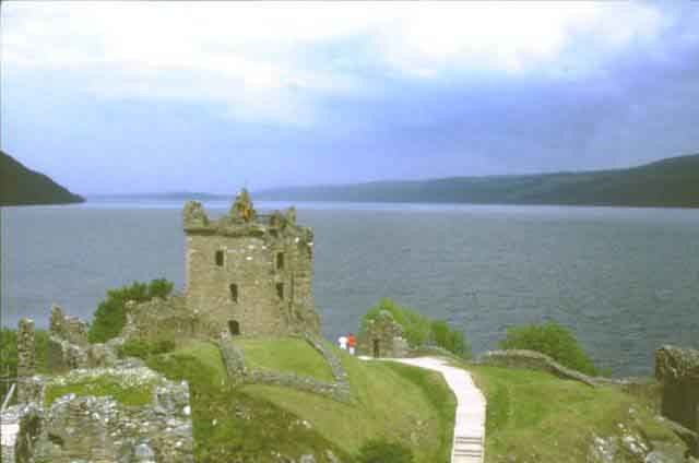 Sunlit Castle Urquhart with a brooding Loch Ness behind